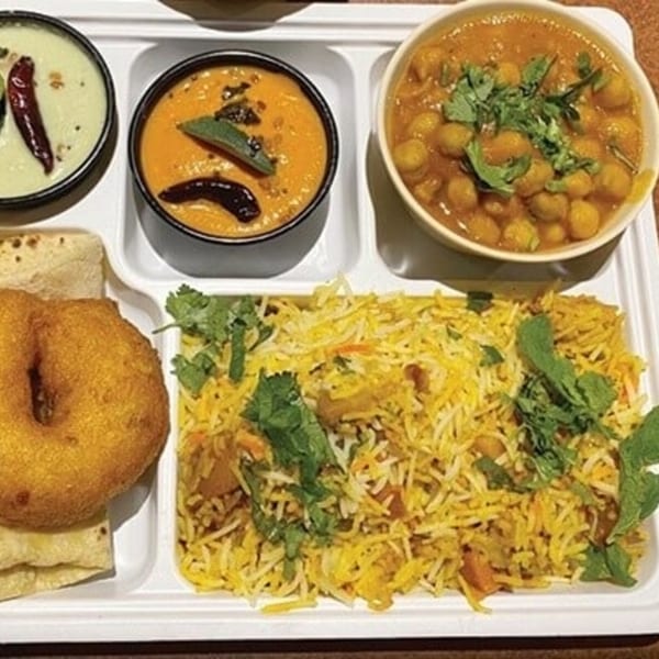 Chennai Dosa Hut's Indian meal with biryani, vada, chickpea curry, and two chutneys on a white tray.